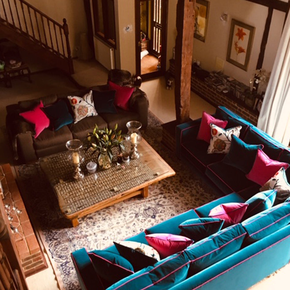 Double storey stitting room with corner sofa and oriental artefacts in a Kentish converted barn