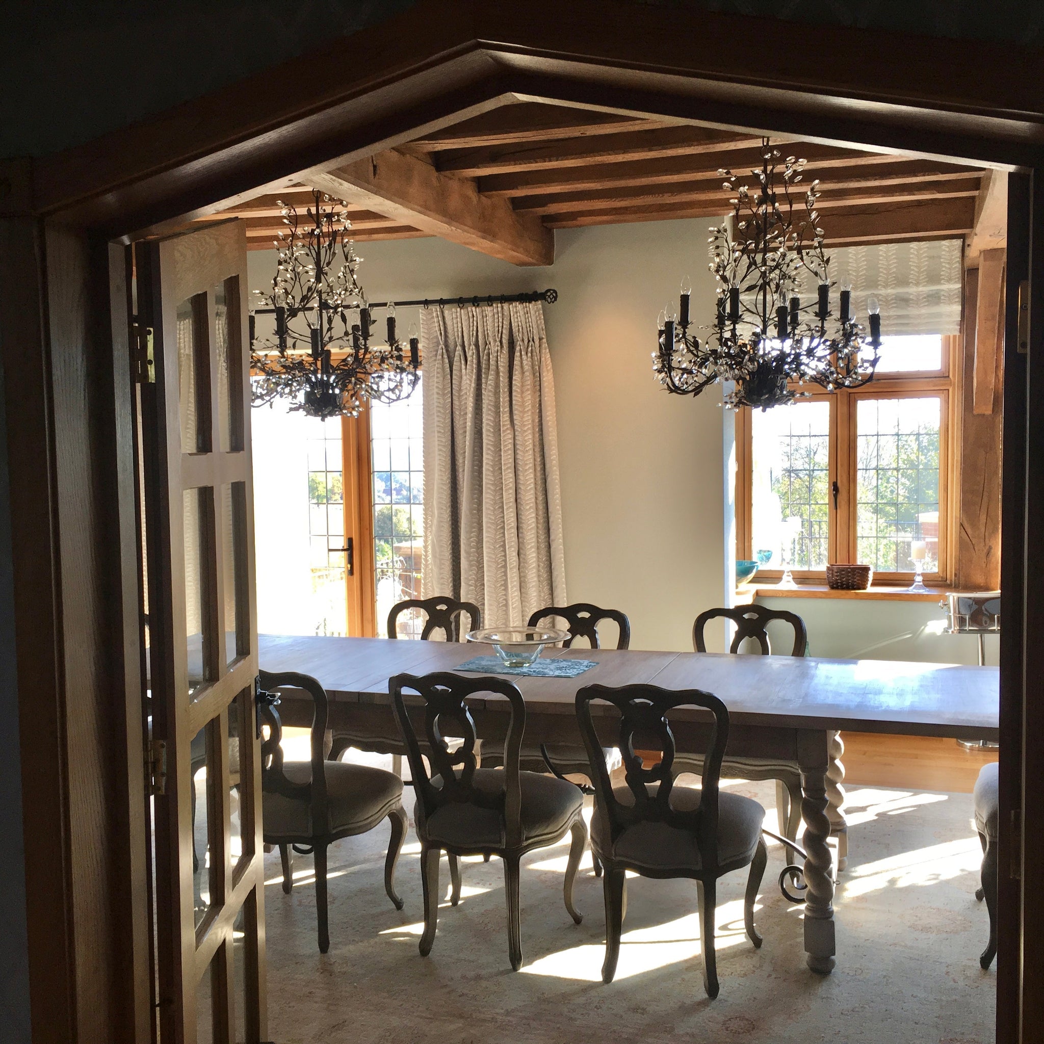 Stunning dining room with embroidered curtains, blinds and chandeliers...