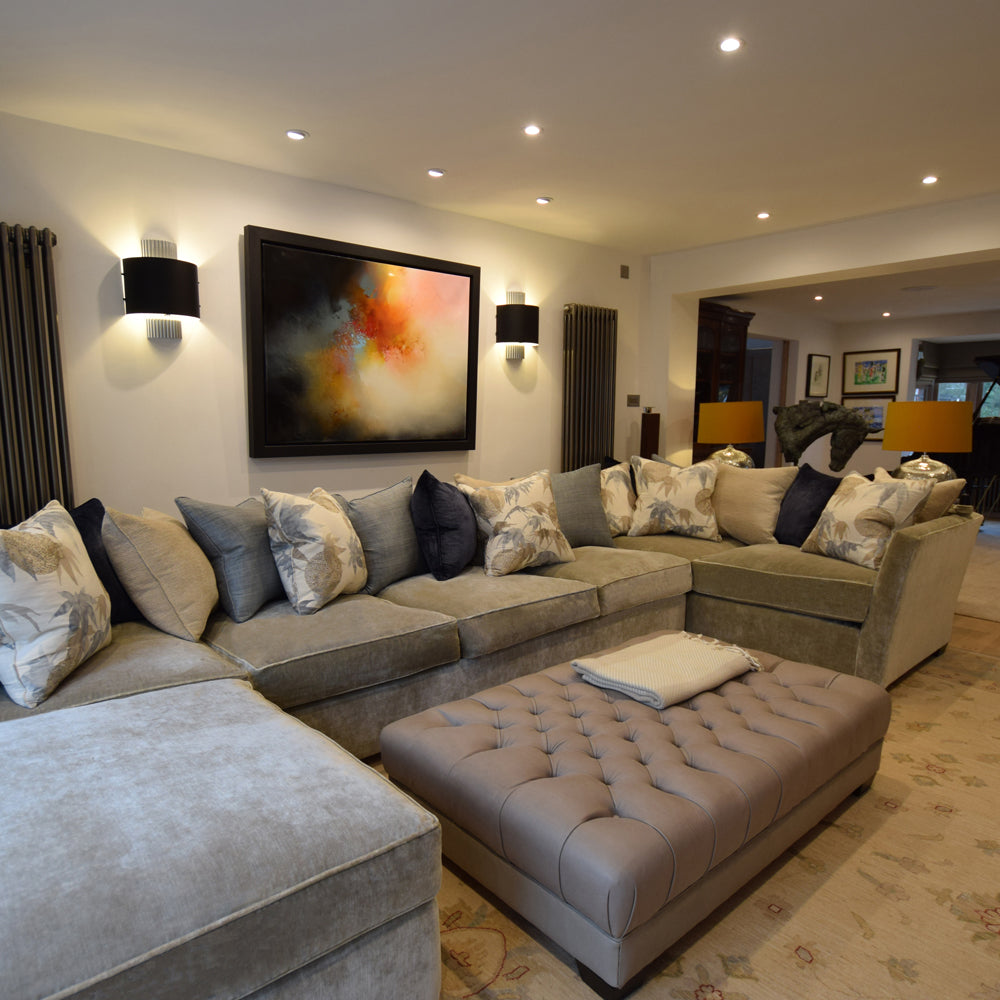 Corner sofa with extended chaise end and buttoned footstool